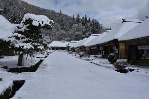 雪に覆われた大内宿の町並みの写真（通りの右側の家を写したもの）