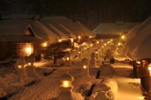 夜の大内宿雪まつりの写真003（雪灯篭の明かりと照明で明るく照らされた町並み）