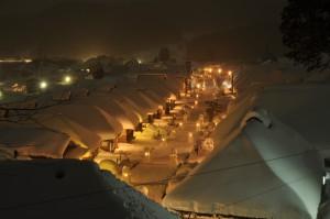 夜の大内宿雪まつりの写真004（雪灯篭の明かりと照明で明るく照らされた町並みを上方から撮ったもの）