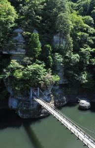 夏の塔のへつりの写真001（岩肌に向かってかかる川の上のつり橋の様子）