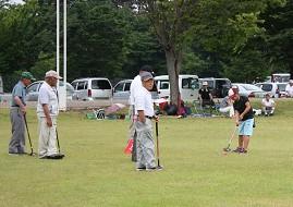 グランドゴルフを楽しむ、お年寄りと小学生の写真